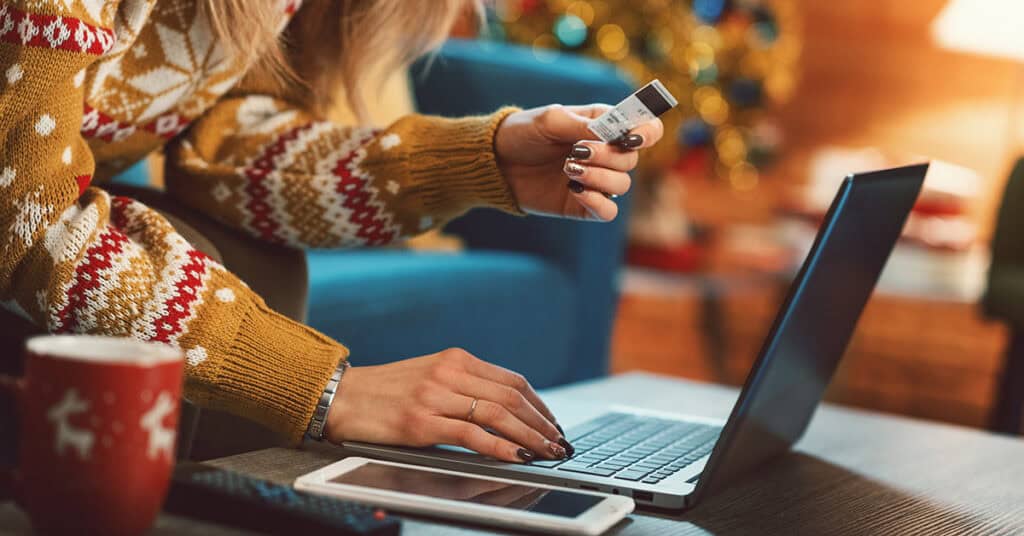 Woman buying gifts online in a festive holiday setting, showing an online store ready for the holiday season.