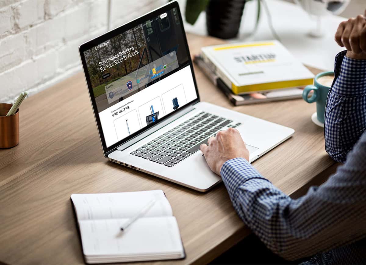 Man sitting at desktop viewing the new ReconView website on a macbook.