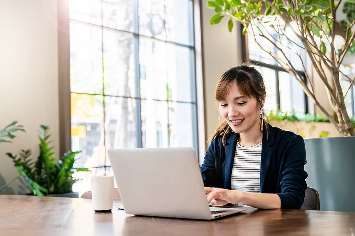 Bookkeeping professional working on a laptop in a modern office environment.